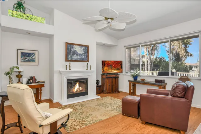 a living room with furniture a fireplace and a large window