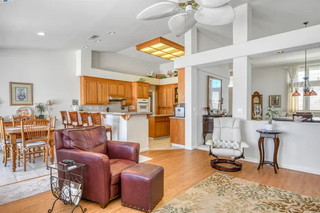 a living room with furniture kitchen view and a chandelier