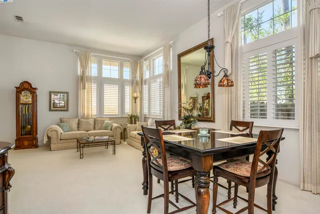 a dining room with furniture and large windows