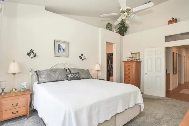 a spacious bedroom with a bed and a chandelier