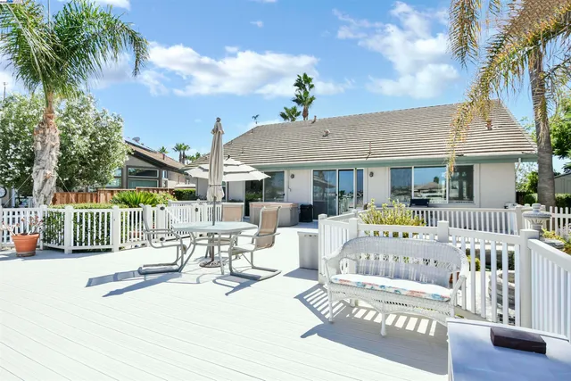 a view of a patio with a table chairs and a small yard