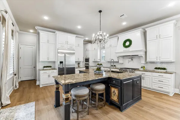 a kitchen with stainless steel appliances granite countertop a stove and cabinets