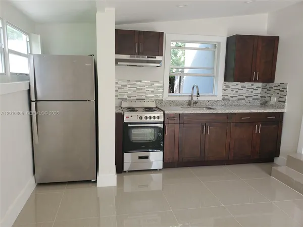 a kitchen with stainless steel appliances a refrigerator sink and cabinets