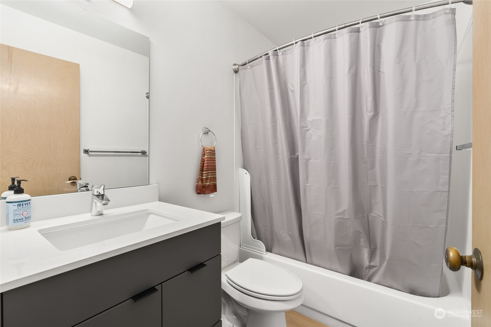 3435 Burke Avenue North Seattle, WA 98103 - Photo 13 of 21 a bathroom with a sink a toilet and shower curtain