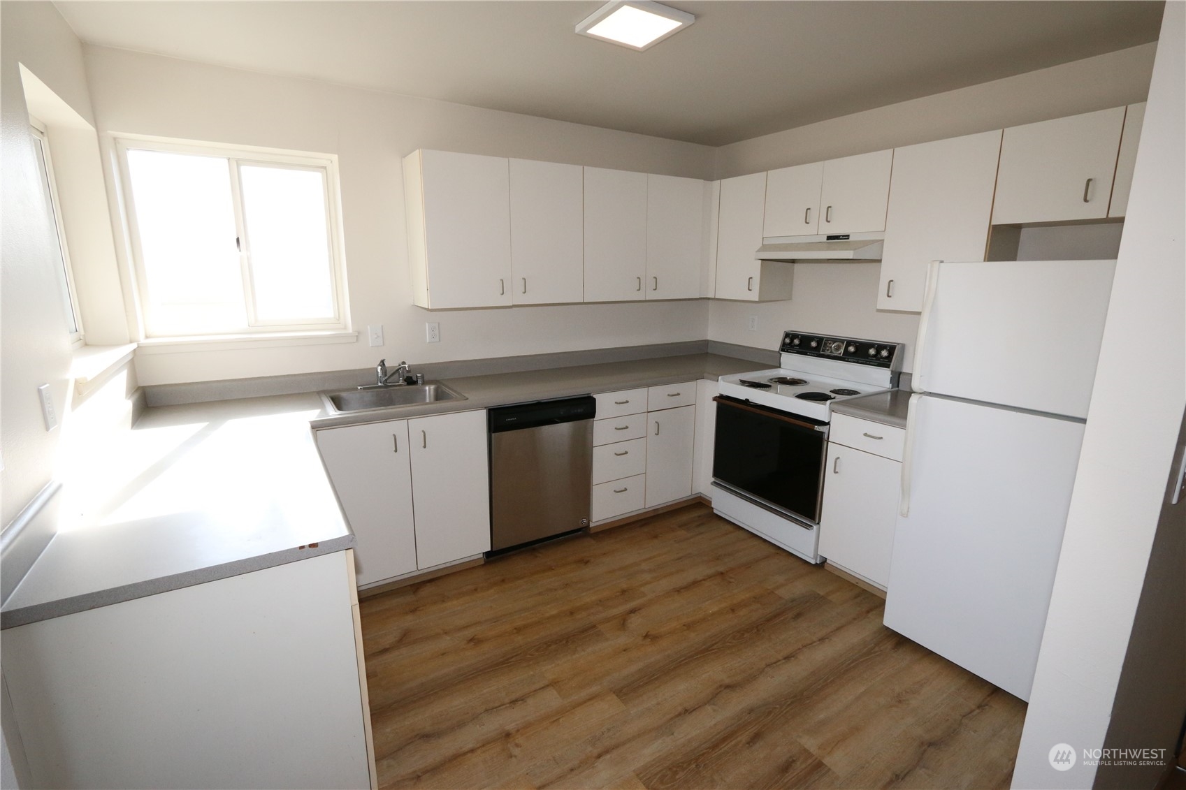 3435 Burke Avenue North Seattle, WA 98103 - Photo 17 of 21 a kitchen with stainless steel appliances granite countertop a stove a refrigerator a sink a stove with white countertops