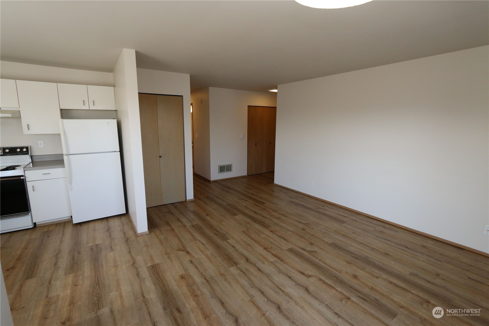 3435 Burke Avenue North Seattle, WA 98103 - Photo 20 of 21 a view of empty room with wooden floor and electronic appliances