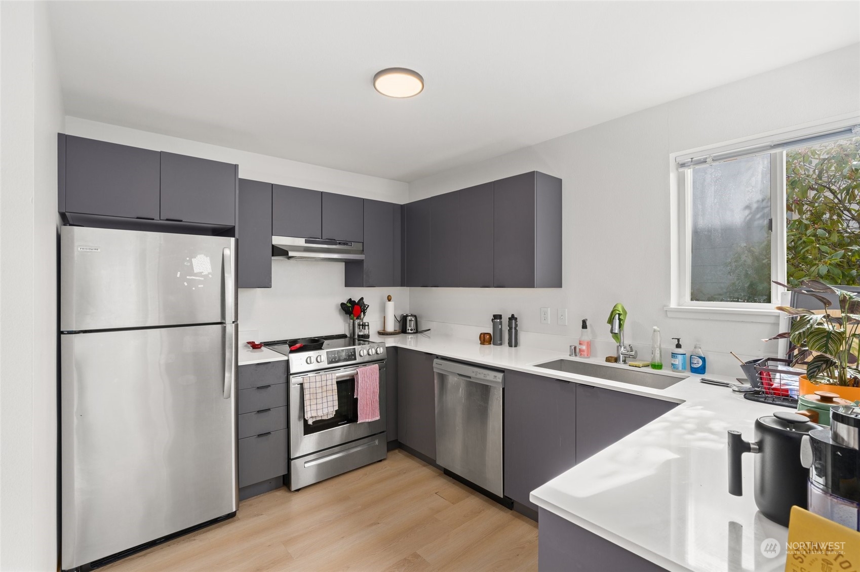 3435 Burke Avenue North Seattle, WA 98103 - Photo 9 of 21 a kitchen with a sink a refrigerator a stove and cabinets