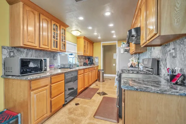 a kitchen with stainless steel appliances granite countertop a refrigerator and a stove