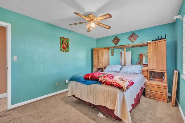 a spacious bedroom with a bed and a chandelier