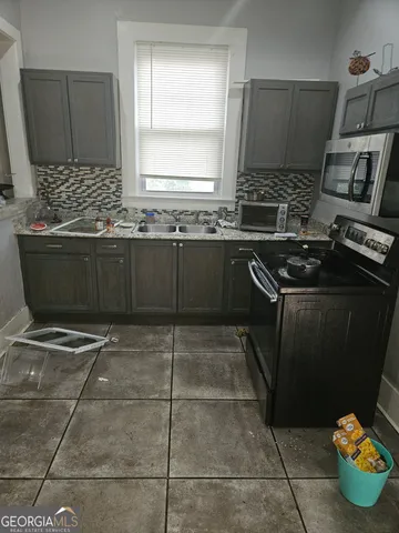a kitchen with stainless steel appliances a stove a sink a microwave and a counter top space