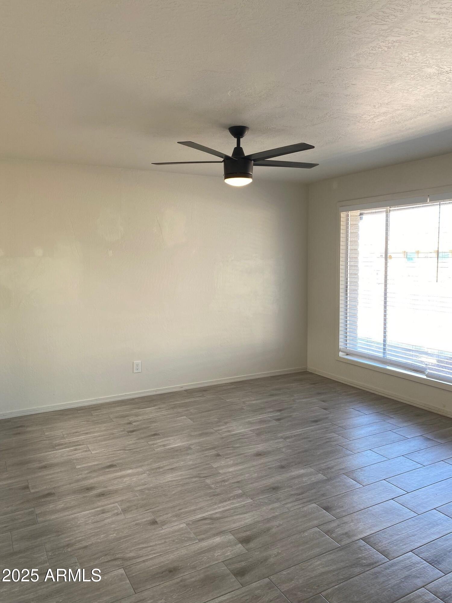 1821 West Libby Street Phoenix, AZ 85023 - Photo 20 of 26 an empty room with wooden floor fan and windows