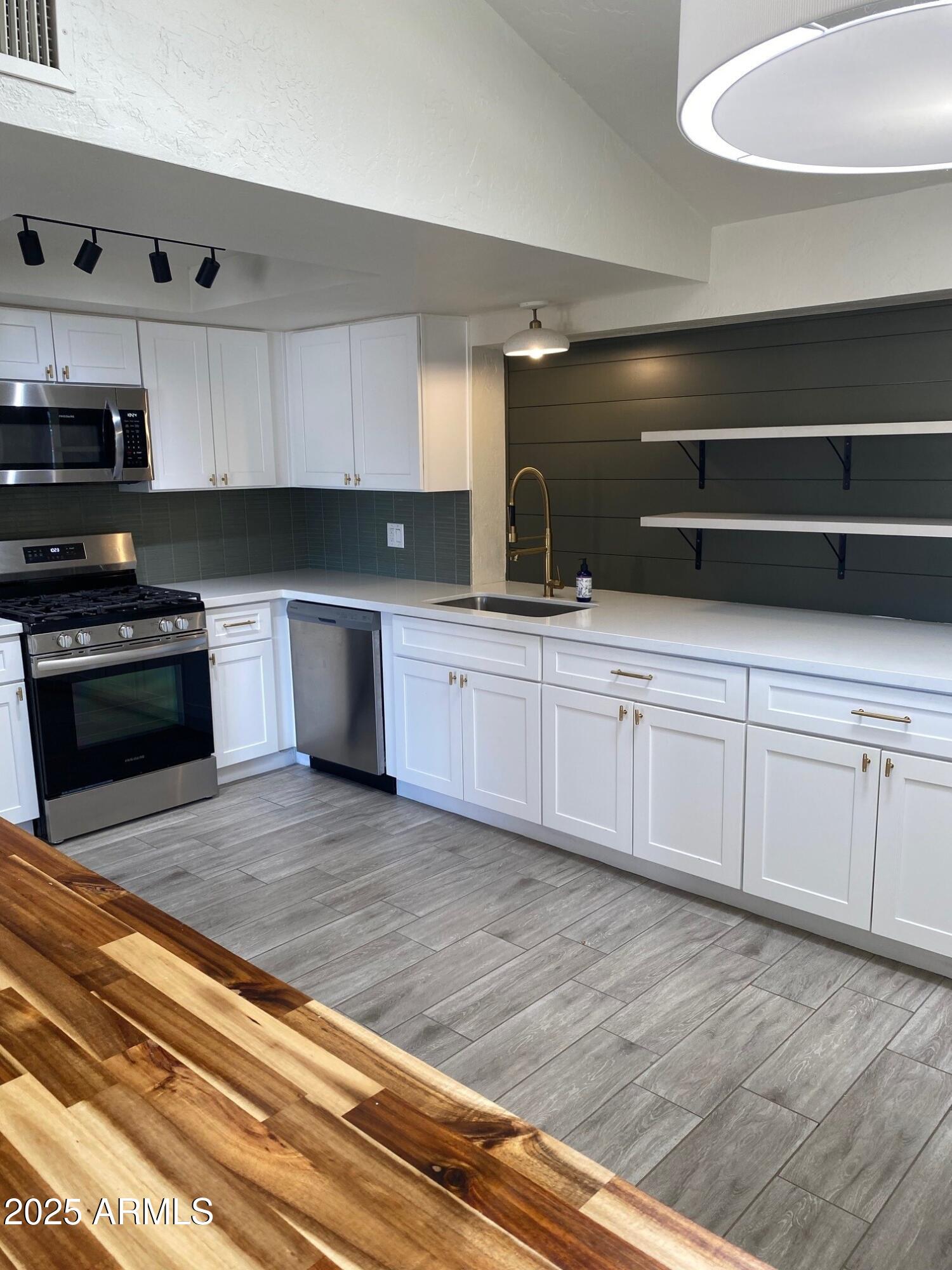 1821 West Libby Street Phoenix, AZ 85023 - Photo 9 of 26 a kitchen with stainless steel appliances granite countertop a sink and a stove