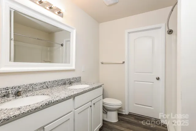 a bathroom with a granite countertop sink toilet and shower