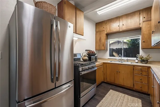 a kitchen with stainless steel appliances a refrigerator sink and stove