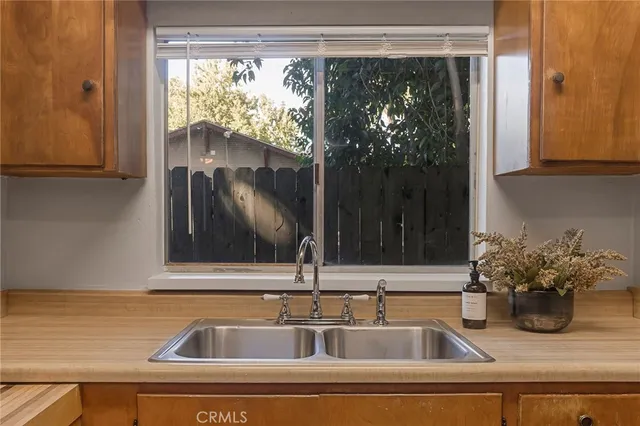 a sink with a granite countertop window and sink
