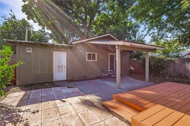 a view of patio with table and chairs under an umbrella with a barbeque