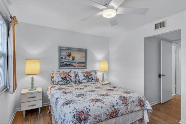 a bedroom with a bed and a lamp on dresser