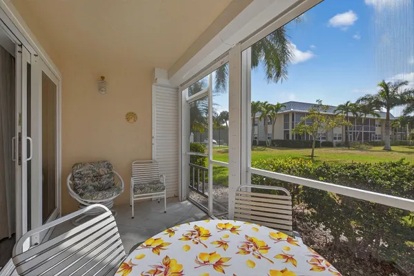 a view of a porch with furniture and floor to ceiling window