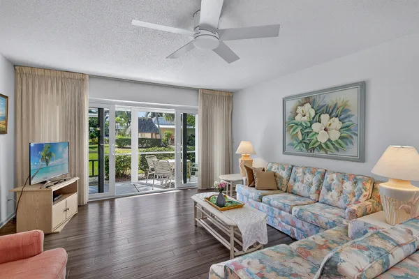 a living room with furniture and a flat screen tv with wooden floor