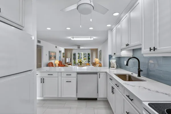 a kitchen with white cabinets and sink