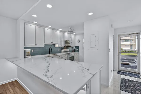 a kitchen with a sink a counter top space stainless steel appliances and cabinets