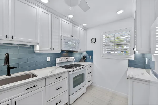 a kitchen with cabinets appliances and a window
