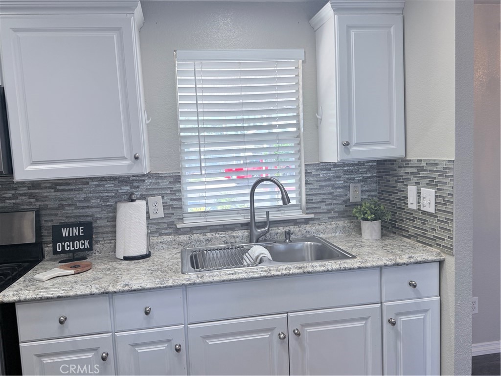 1855 Riverside, Unit 405 Ontario, CA 91761 - Photo 11 of 25 a kitchen with granite countertop a sink and cabinets