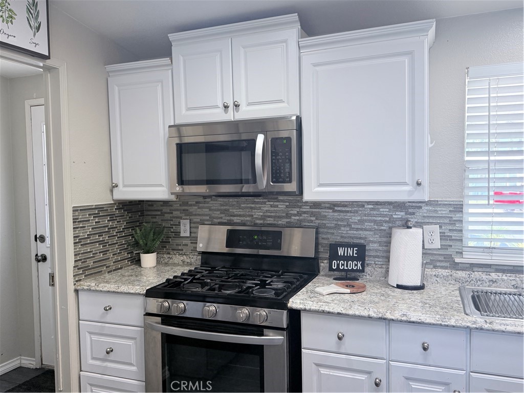 1855 Riverside, Unit 405 Ontario, CA 91761 - Photo 12 of 25 a kitchen with granite countertop white cabinets and stainless steel appliances