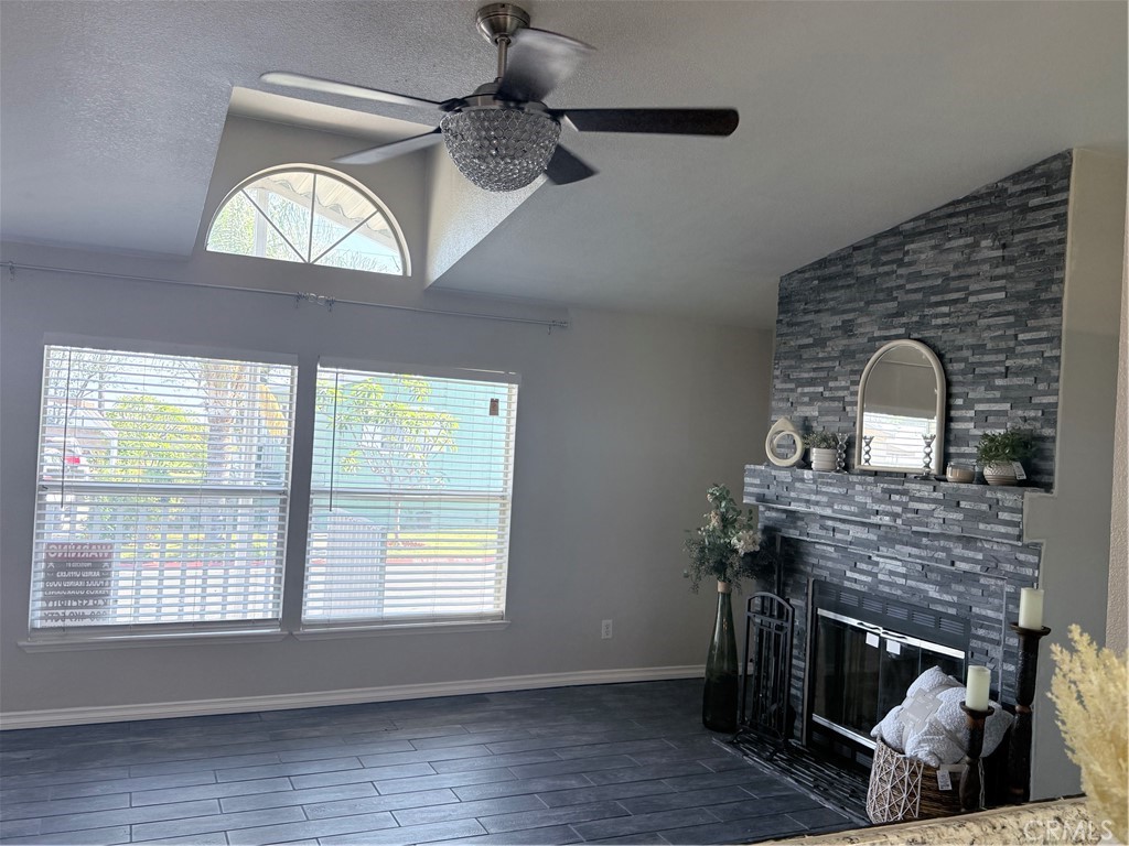 1855 Riverside, Unit 405 Ontario, CA 91761 - Photo 4 of 25 a living room with a fireplace furniture a ceiling fan and a window