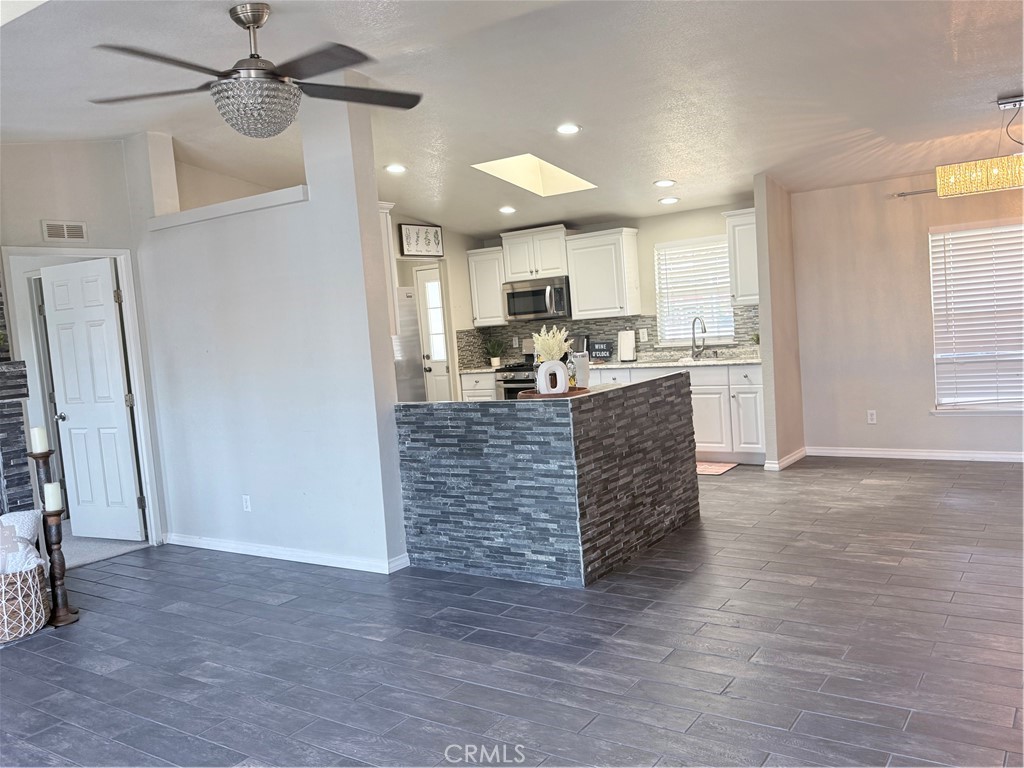 1855 Riverside, Unit 405 Ontario, CA 91761 - Photo 7 of 25 a kitchen with stainless steel appliances kitchen island granite countertop a stove and a refrigerator
