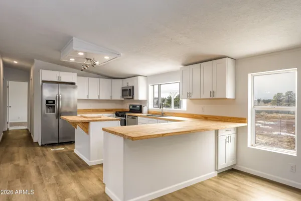 a kitchen that has a lot of cabinets in it and appliances