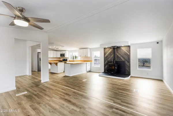 a view of an empty room with window and wooden floor