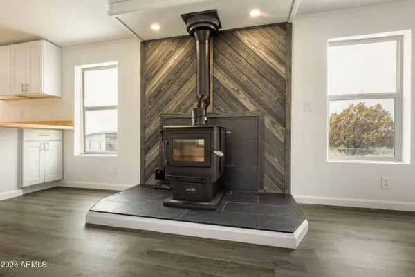 a kitchen with stainless steel appliances a stove a sink dishwasher a refrigerator white cabinets and wooden floor