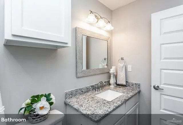 a bathroom with a granite countertop sink and a mirror