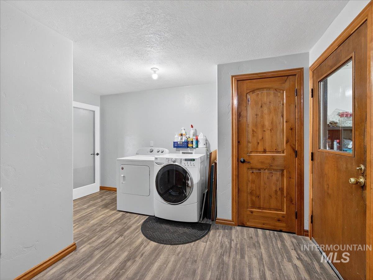 2588 West Sales Yard Road Emmett, ID 83617 - Photo 22 of 50 Laundry area with a textured ceiling, wood finished floors, and independent washer and dryer