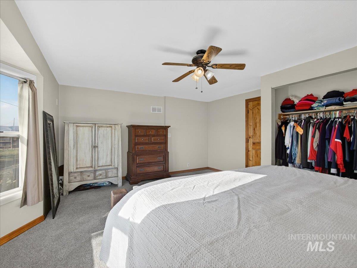 2588 West Sales Yard Road Emmett, ID 83617 - Photo 25 of 50 Bedroom featuring carpet floors, a ceiling fan, and a closet