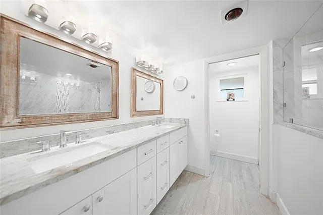 a spacious bathroom with a granite countertop sink mirror and a shower
