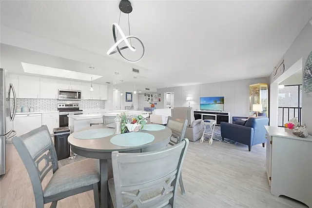 a kitchen with a dining table chairs refrigerator and microwave