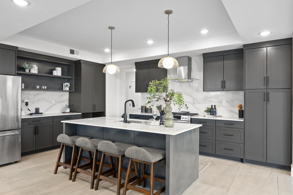 101 Fall Drive Georgetown, TX 78633 - Photo 11 of 40 a kitchen with kitchen island granite countertop a sink a stove a refrigerator and chairs