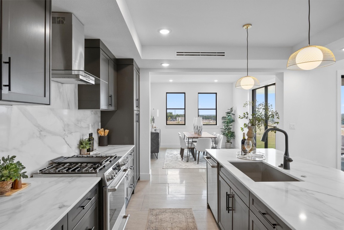 101 Fall Drive Georgetown, TX 78633 - Photo 15 of 40 a kitchen with stainless steel appliances granite countertop a sink a stove and a wooden floors