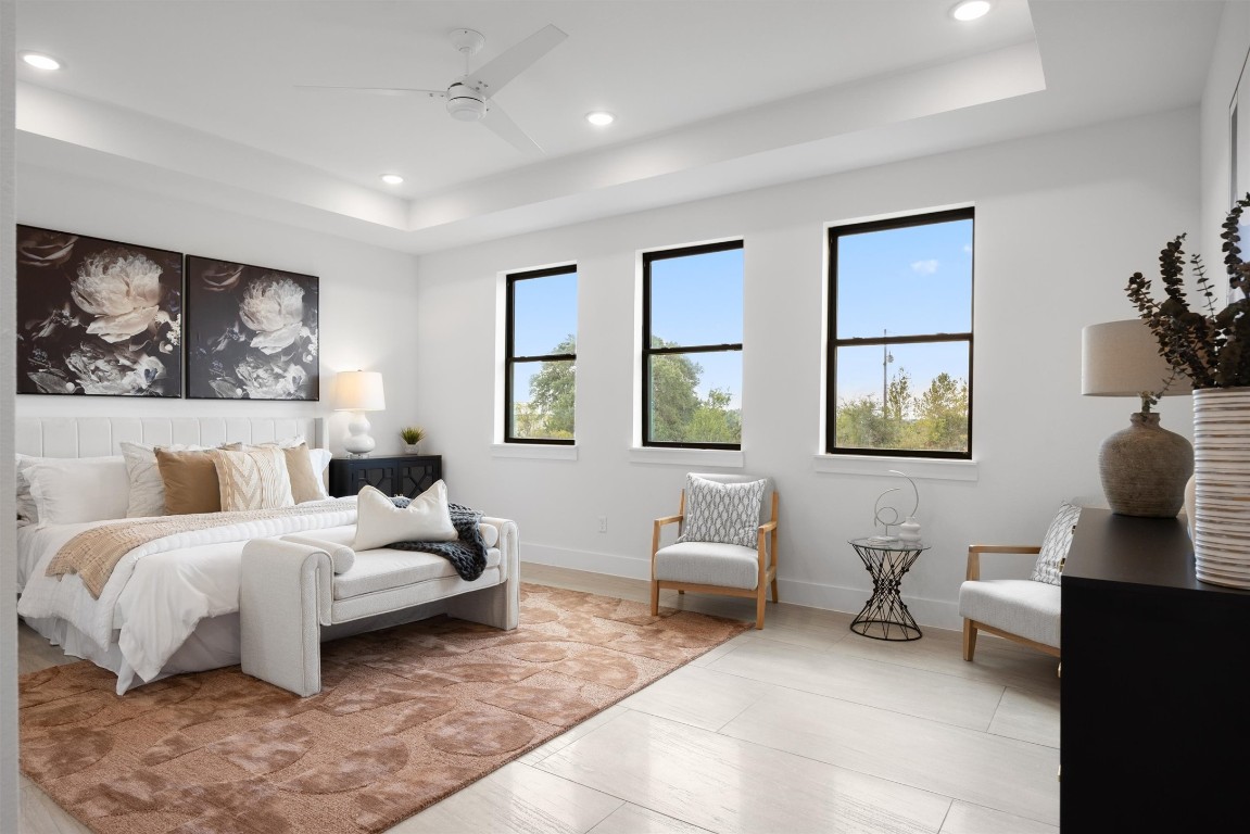 101 Fall Drive Georgetown, TX 78633 - Photo 16 of 40 a spacious bedroom with a bed a couch and paintings on the wall