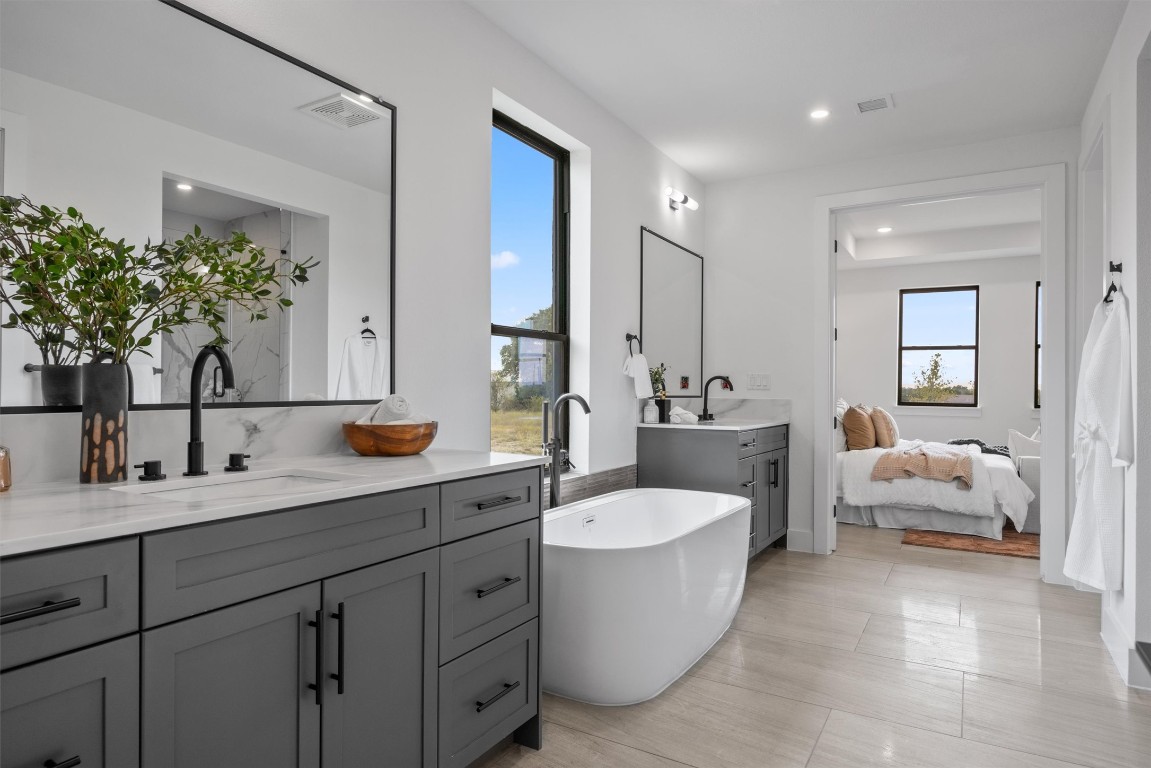 101 Fall Drive Georgetown, TX 78633 - Photo 20 of 40 a spacious bathroom with a double vanity sink a mirror and a bathtub