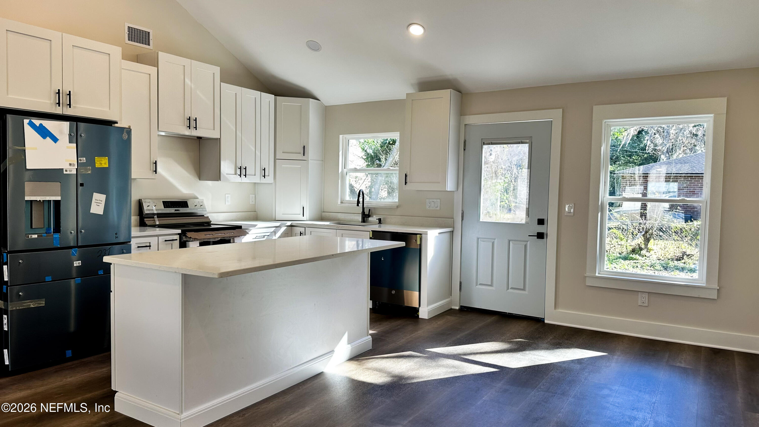 86549 Hester Drive Yulee, FL 32097 - Photo 5 of 18 a kitchen with kitchen island granite countertop white cabinets and window