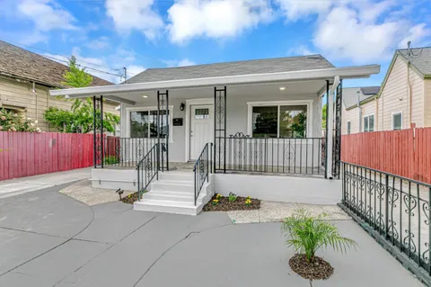 a view of a house with a small yard and wooden fence