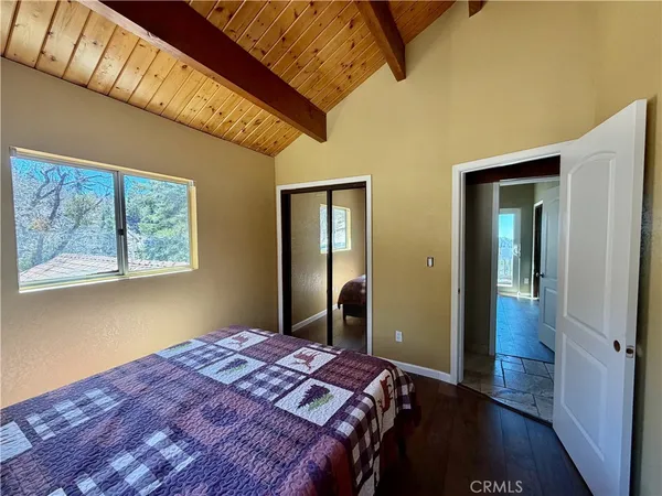 a bedroom with bed and wooden floor