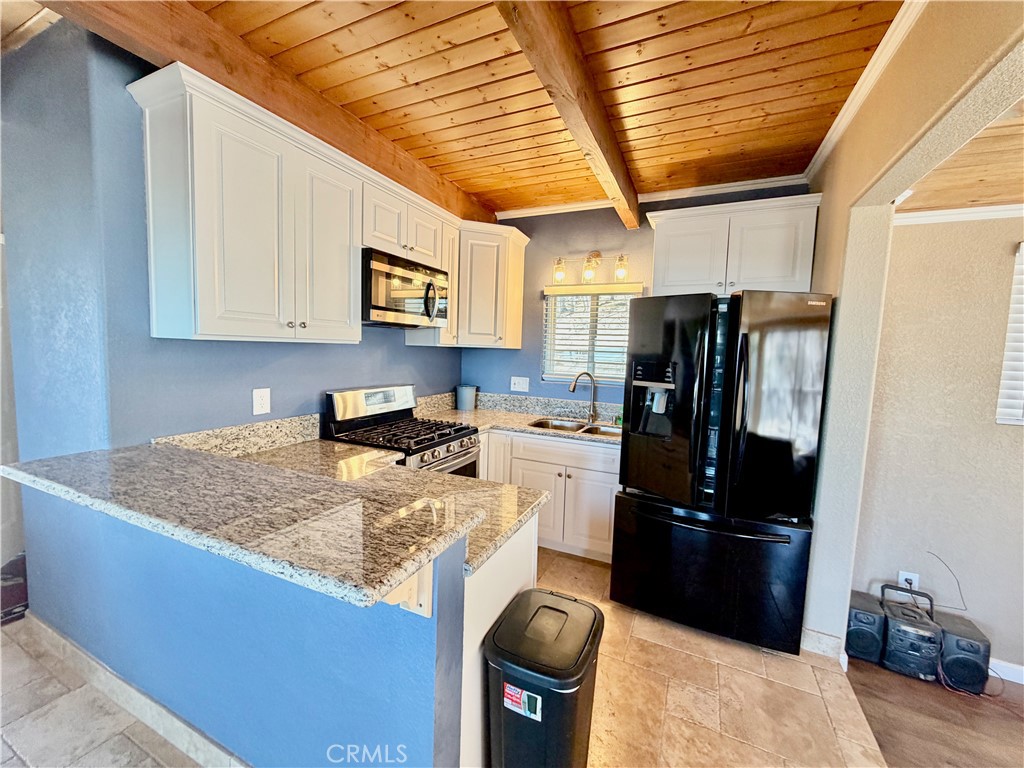 2190 Tank Running Springs Running Springs, CA 92382 - Photo 6 of 33 a kitchen with stainless steel appliances granite countertop a sink stove and refrigerator