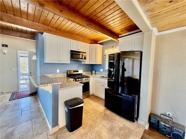 a kitchen with stainless steel appliances granite countertop a refrigerator stove and sink
