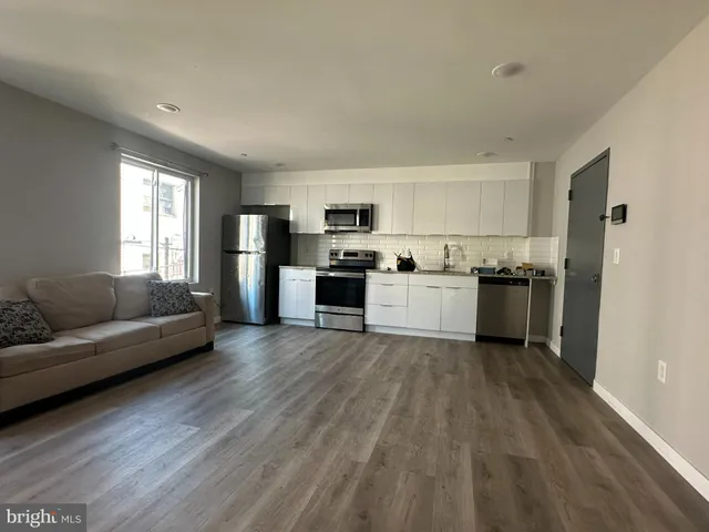 a view of a kitchen with cabinets stainless steel appliances and a window