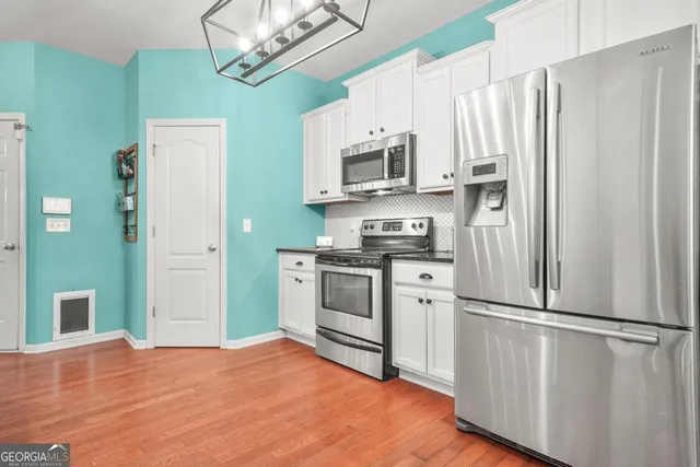 a kitchen with stainless steel appliances white cabinets and a refrigerator