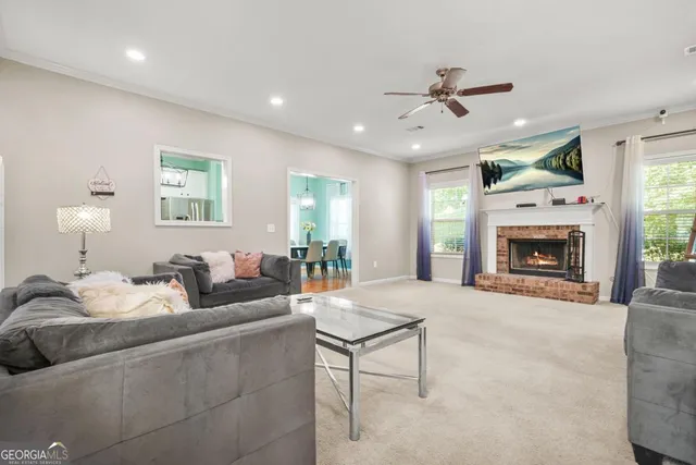 a living room with furniture a fireplace and a ceiling fan